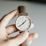 person holding analog watch